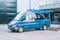 Mercedes-Benz Sprinter van parked in urban area. Blue passenger medium size commercial minibus, front side view