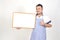 Merchant Asian man in white and blue apron to holding blank white broad for put some text or wording for present advertising