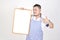 Merchant Asian man in white and blue apron to holding blank white broad for put some text or wording for present advertising