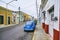 Merida / Yucatan, Mexico - June 1, 2015: The vintage blue car parking infront of the old red and yellow building in Merdia, Yucata