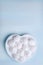 Meringue cake on a white porcelain plate in the shape of a heart. Photos of desserts for proper nutrition. Valentine's