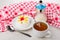 Meringue with fruits in saucer, cup of tea, sugar bowl