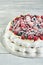 Meringue pavlova wreath cakes with whipped cream and fresh berries