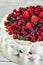 Meringue pavlova wreath cakes with whipped cream and fresh berries