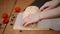 Meringue roll is decorated with berries on a wooden board. Chef cuts meringue roulade on wooden cutting board