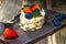 Meringue roll on a wooden tray with a golden fork. strawberries, blueberries and mint