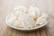 Meringue in white saucer on wooden table