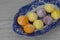 Meringues, various colours, on a patterned blue and white plate.