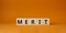 Merit symbol. Concept word Merit on wooden cubes. Beautiful orange background. Business and Merit concept. Copy space