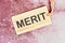 Merit word written on a card with a rope on an abstract background