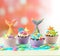 Mermaid theme cupcakes with colorful glitter tails, shells and sea creatures.