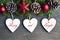 Merry and Bright.Christmas decoration with fir tree,pine cones, and white wooden hearts on old wooden background.