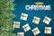 Merry Christmas banner. Green fir tree branches on blue background with falling snow and white and golden gift boxes with bows