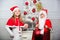 Merry christmas. Boy kid dressed as santa with white artificial beard and red hat give gift box to girl. Kids celebrate