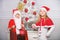 Merry christmas. Boy kid dressed as santa with white artificial beard and red hat give gift box to girl. Kids celebrate