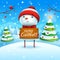 Merry Christmas! Cheerful snowman holds wooden board sign in Christmas snow scene winter landscape.