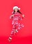 merry christmas. cheerful teen girl in red christmas santa hat running in studio. santa girl
