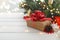 Merry Christmas. Christmas gifts and surprises on a white wooden table next to branches of a Christmas tree and shining lights.