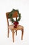 Merry Christmas! Christmas wreath on rustic chair in snowy winter field. Winter holidays in countryside. Stylish xmas wreath with