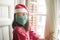 Merry Christmas during covid19 - young beautiful and happy Asian Japanese woman in  face mask and Santa Claus hat enjoying xmas