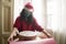 Merry Christmas during covid19 - young beautiful and happy Asian Korean woman in  face mask and Santa Claus hat wrapping xmas