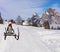 Merry Christmas a funny penguin wearing a santa claus hat and scarf sliding down the ski hill slope on a sleigh