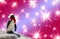 Merry christmas a funny penguin wearing a shawl and santa claus hat isolated on a colorful background with shiny stars