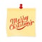 Merry Christmas hand written on yellow sticky note attached with red pin. Realistic sticker and pushpin isolated on white.