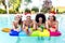 Merry christmas! happy diverse group of friends portrait wearing xmas santa hat having drinks in swimming pool party celebrating