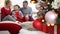 Merry christmas, happy family at home, parents give Christmas present to their surprised and curious son near the illuminated and