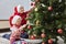 Merry Christmas and Happy Holidays. Happy family grandma and granddaughter cheerfully decorate the Christmas tree at