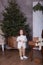 Merry Christmas and happy holidays! New Year 2020. little curly girl stands next to gifts on chair. child receives a Christmas pre