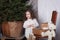Merry Christmas and happy holidays! New Year 2020. little curly girl stands next to gifts on chair. child receives a Christmas pre