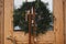 Merry Christmas and Happy holidays! Stylish christmas rustic wreath with vintage bells and ribbon hanging on wooden doors, close