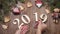 Merry Christmas and happy new year 2019 2020 concept. Female hands puts wood symbols 2019 on wooden background where new