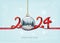 Merry Christmas and Happy New Year background with numbers 2024 from a red ribbon