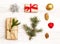 Merry Christmas and Happy New Year composition. Christmas gift, balls, pine cones, fir branches on wooden white background