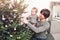Merry Christmas and Happy New Year! Father and son decorate the Christmas tree in living room for holiday. Portrait loving family