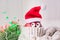 Merry Christmas and Happy New Year. Funny apple with eyes and Santa Claus hat on a light background