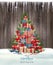 Merry Christmas and Happy New Year holiday wooden background with christmas tree made out of colorful presents.