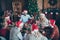 Merry christmas large family reunion gathering meeting sit table have x-mas feast father in santa claus hat cap joke