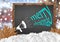 Merry Christmas and megaphone on blackboard with city leaves and snow