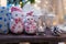 Merry Christmas present box, two snowman toys and white candle. Festive warm garland lights background with bokeh.