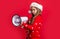 merry christmas. serious santa teen girl with loudspeaker for sale on red christmas background.