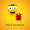 Merry Christmas! - Smiling Emoji with Pop Out Eyes and Red Gift Box - Simple Shiny Happy Emoticon on Yellow Background