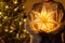 Merry Christmas! Stylish illuminated golden star in hands on background of modern decorated christmas tree with golden lights in