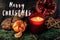 Merry christmas text sign with candle garnet cookies fruits on s