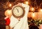 Merry christmas. Time for miracles. Few minutes left. Time for winter party. Woman Santa hat hold vintage clock. Time to