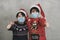 Merry Christmas,two kids with medical mask and Santa Claus hat doing victory sign