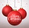 Merry christmas typography greetings in a hanging red christmas balls